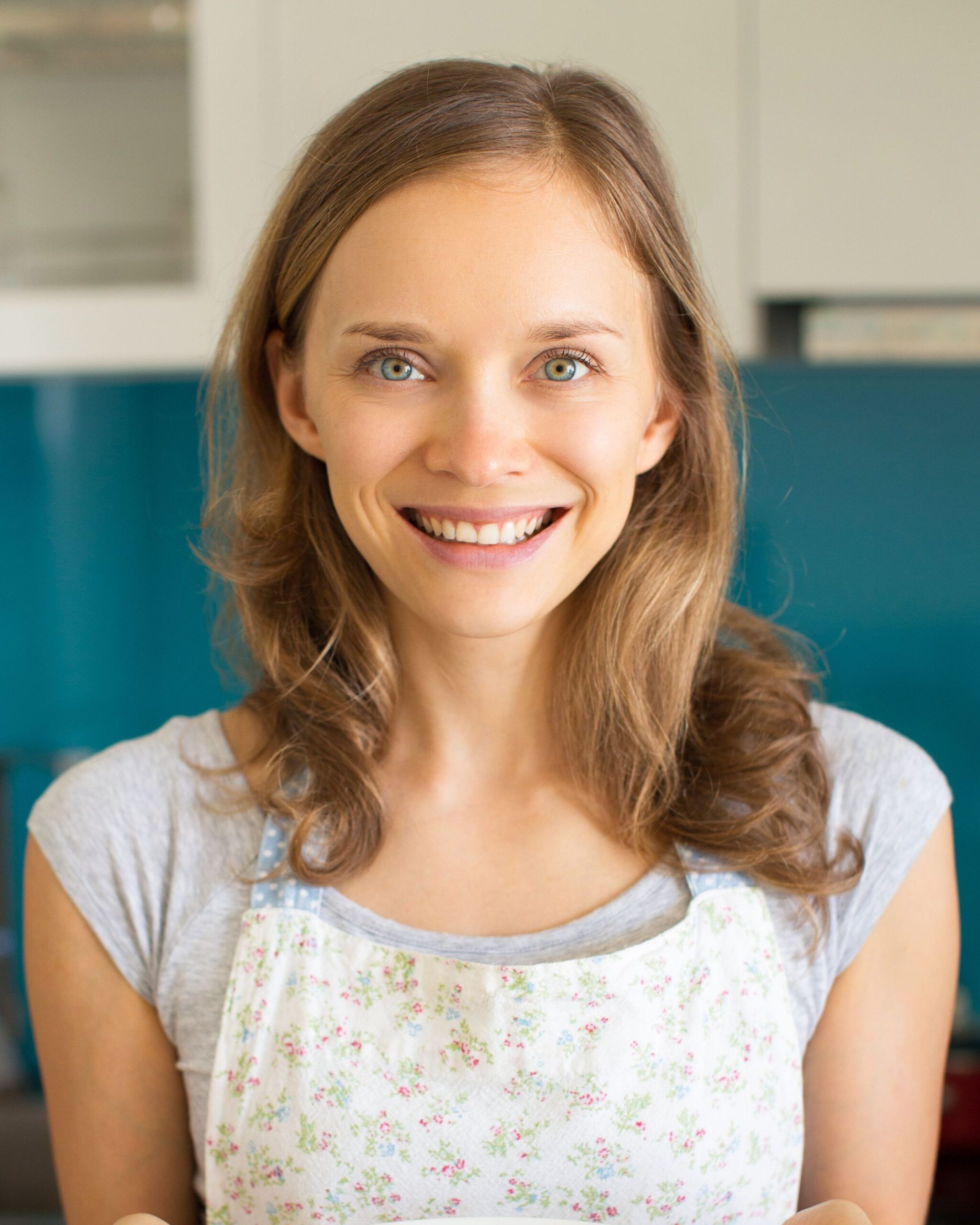 Smiling Woman Holding Plate with Sliced Vegetables