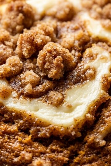 Ultra close-up macro of bakery style pumpkin cream cheese muffins with streusel and cheesecake swirl