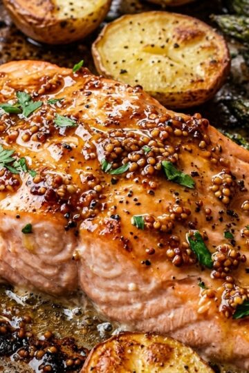 Ultra close-up macro food photography of Sheet Pan Maple Dijon Glazed Salmon with crispy potatoes and asparagus